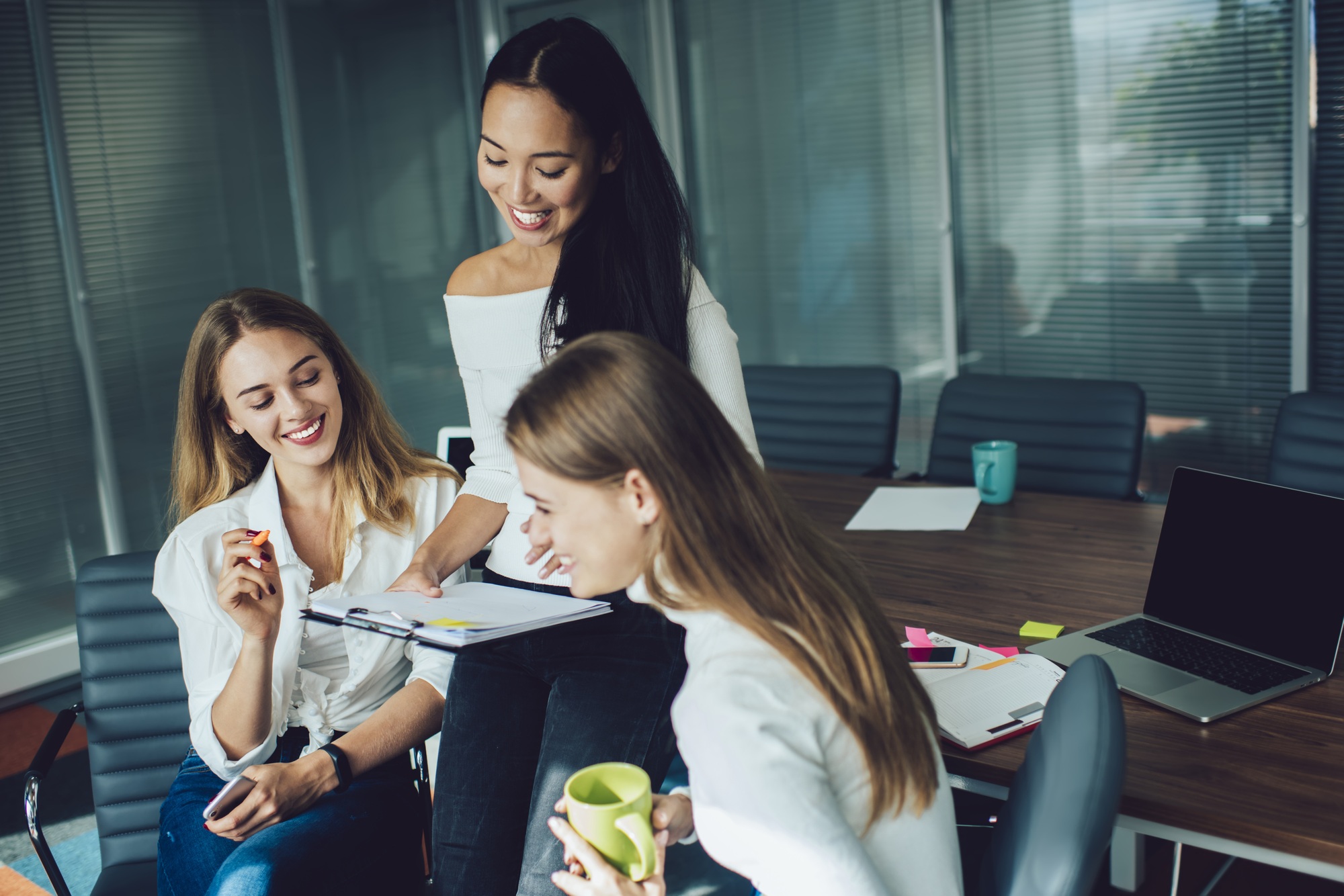 Joyful multicultural colleagues talking about startup project and productive strategy