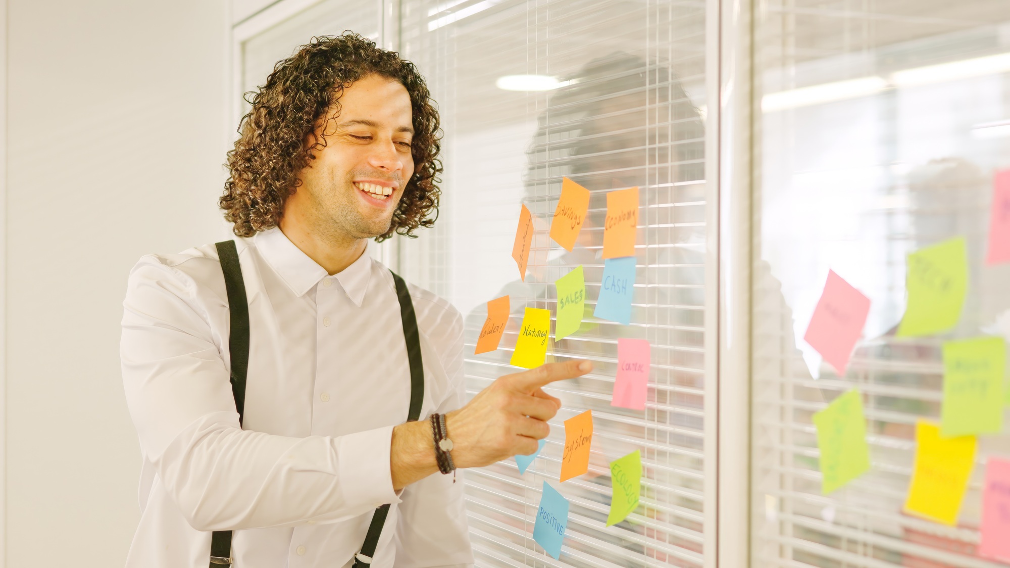 Man pointing a post-it presenting ideas in a meeting