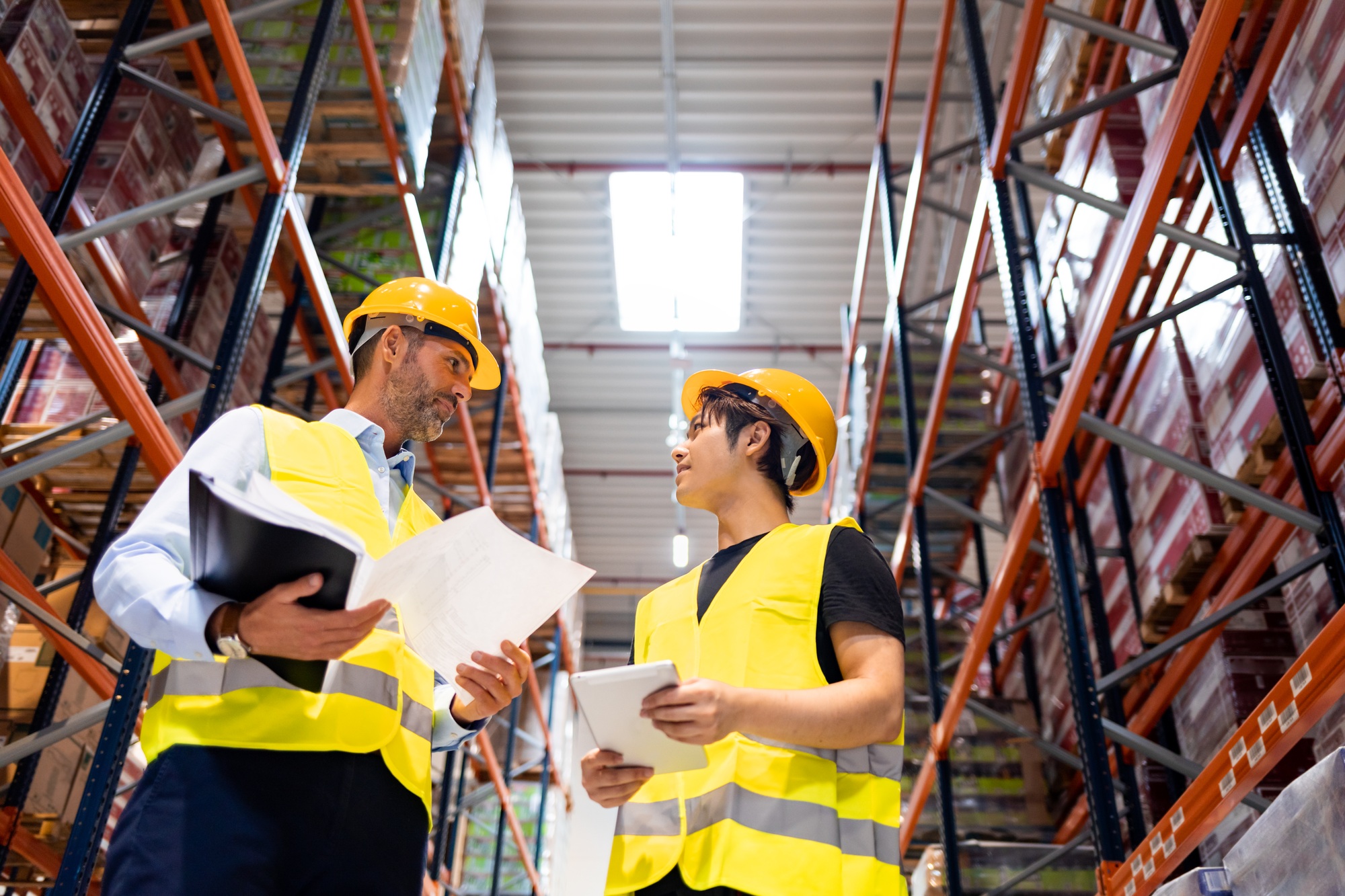 Warehouse workers checking inventory with plans in hand