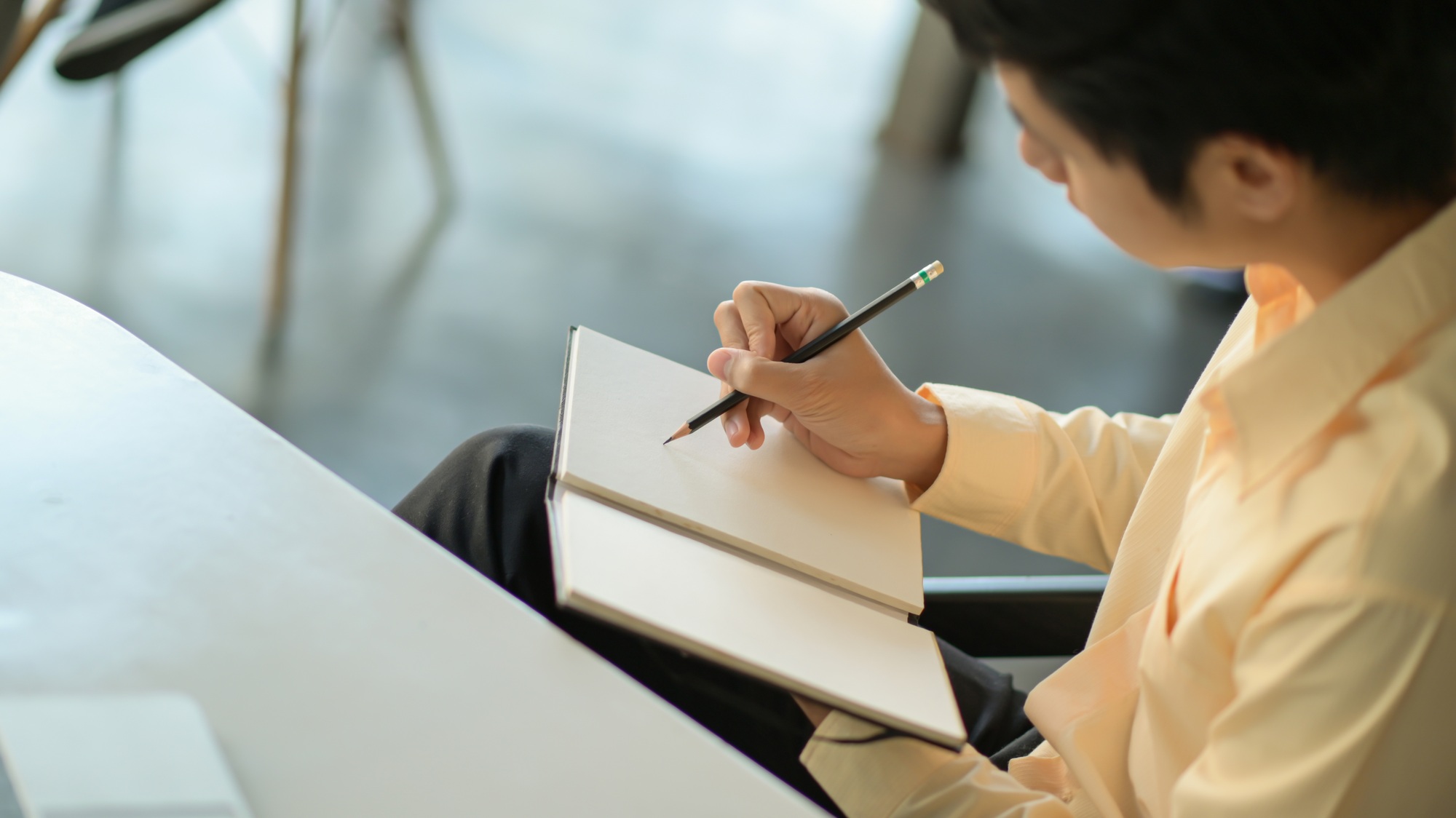 Young business man is recording the work schedule in the notebook.