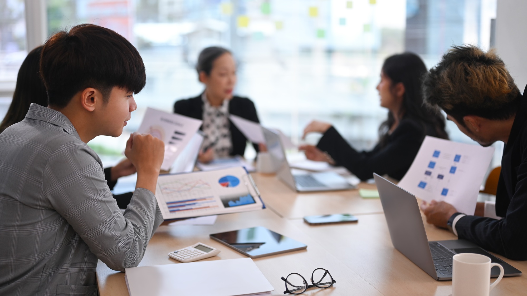 Concentrated diverse employees listening intently during discussion of development.
