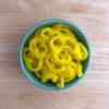 Sliced, yellow pickled banana peppers are shown in a blue bowl.