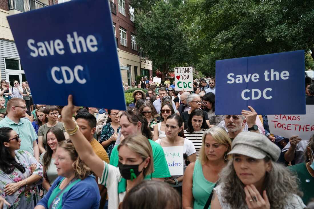 Employees and supporters of the Centers for Disease Control (CDC) hold signs and clap and cheer to honor former Centers for Disease Control (CDC) officials Dan Jernigan, Deb Houry, and Demetre Daskalakis outside its global headquarters on August 28, 2025 in Atlanta, Georgia. The three officials were honored after resigning in the wake of U.S. President Donald Trump's attempted firing of CDC director Susan Monarez.