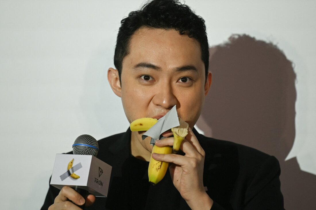 Chinese-born crypto founder Justin Sun eats a banana artwork composed of a fresh banana stuck to a wall with duct tape, in Hong Kong on November 29, 2024, after buying the provocative work of conceptual art by Italian artist Maurizio Cattelan at a New York auction for $6.2 million. The debut of the edible creation entitled "Comedian" at the Art Basel show in Miami Beach in 2019 sparked controversy and raised questions about whether it should be considered art -- Cattelan's stated aim.