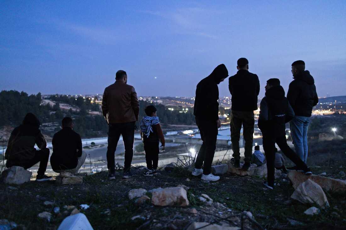 Family members and relatives of Palestinian prisoners, wait for their release, while standing on a hill above the Ofer Prison, in the west of Ramallah on Jan. 19, 2025.
