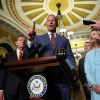 In this photo, Senate Majority Leader John Thune is standing behind a wooden lectern at the U.S. Capitol as he gives a statement.