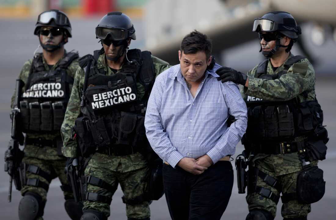 Soldiers escort a man who authorities identified as Omar Trevino Morales, alias "Z-42," leader of the Zetas drug cartel, as he is moved from a military plane to a military vehicle at the Attorney General's Office hangar in Mexico City, March 4, 2015.