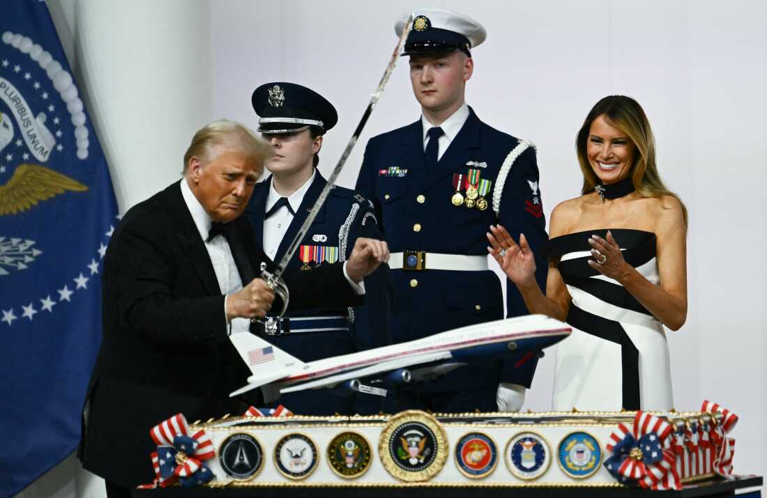 First Lady Melania Trump laughs as she watches President Trump cut with a saber into a cake representation of the new Air Force One design during the Commander-In-Chief inaugural ball at the Walter E. Washington Convention Center in Washington, DC on Monday.