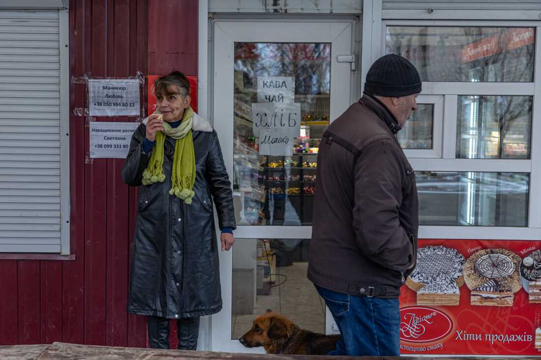 Svitlana Storozhko, owner of a small grocery, drinks coffee by the entrance of her shop in the center of Pokrovsk.  "We believe in God and in Ukraine's armed forces," she said, explaining her decision to stay in the besieged city.