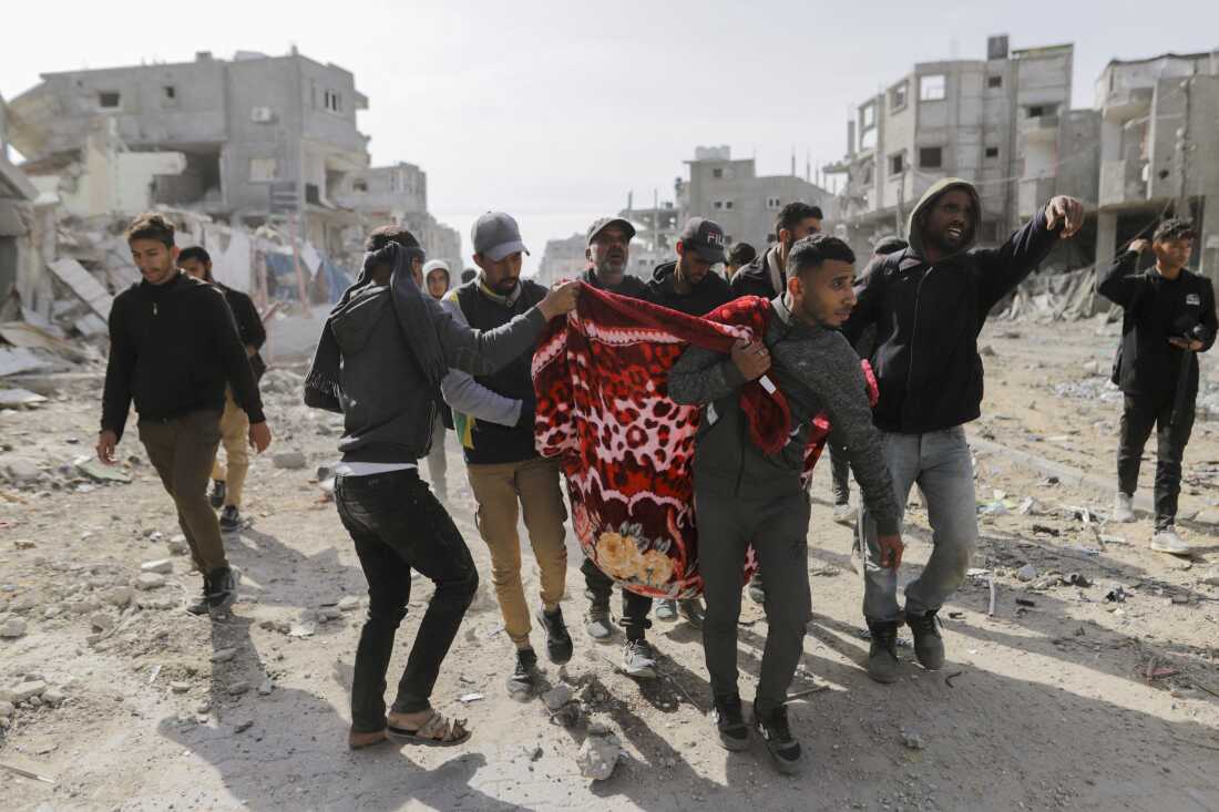 Palestinians carry a wounded man through the streets of Rafah, Gaza Strip, on January 19, 2025.