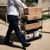 A worker wheels out the belongings of a fellow employee who was dismissed, outside of the Mary E. Switzer Federal Office Building, which houses offices for the US Department of Health and Human Services in Washington, DC, on Tuesday.