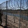 A U.S. Army soldier standing at a razor-wire-topped fence monitors the border with Mexico in Eagle Pass, Texas.