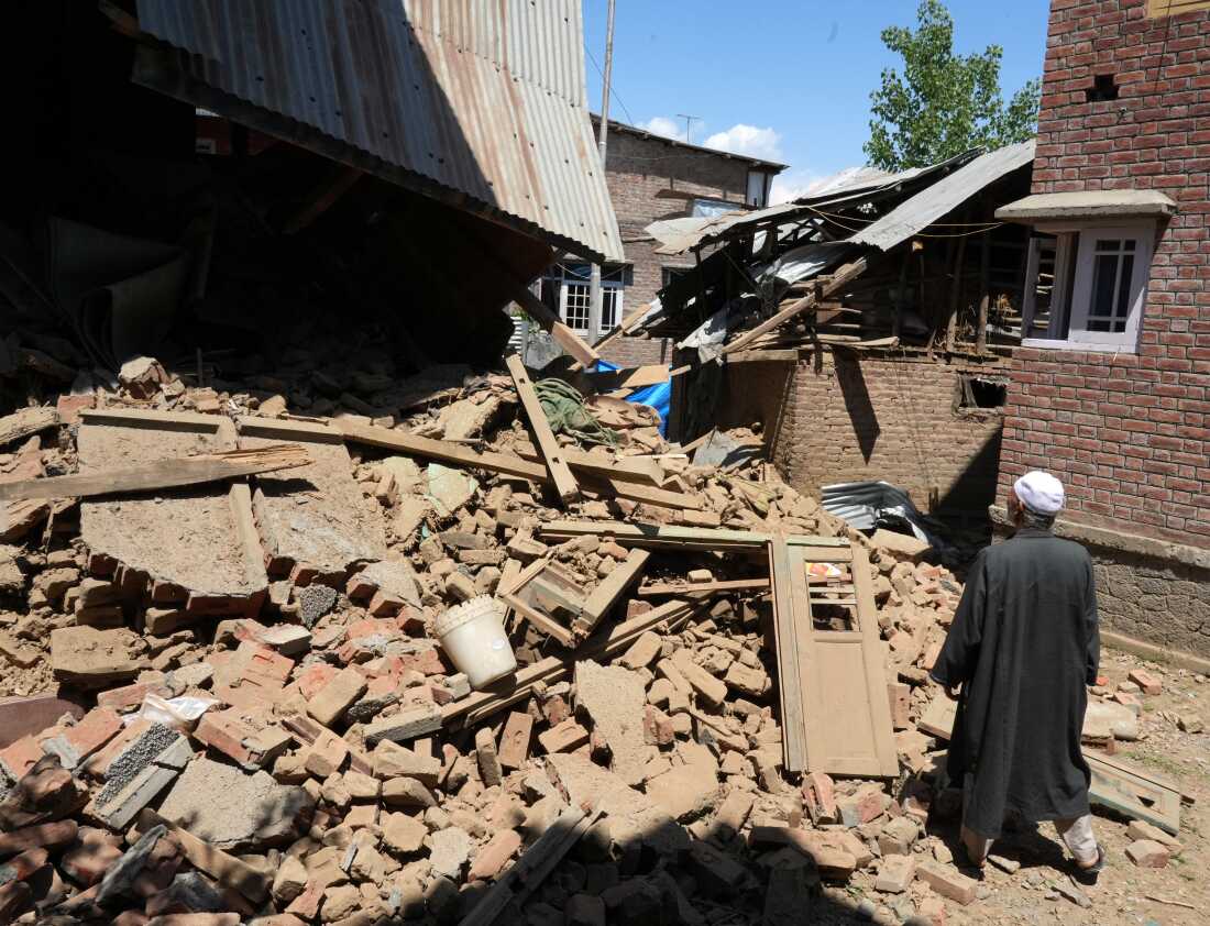 An elderly man inspecting the demolished family house of Kashmiri militant Adil Thoker in Guree village of South Kashmir.