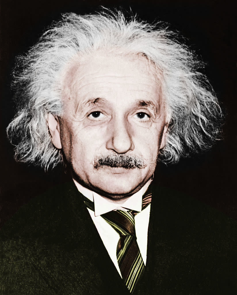 Person with a thoughtful expression, iconic hairstyle, and mustache, wearing a suit and tie