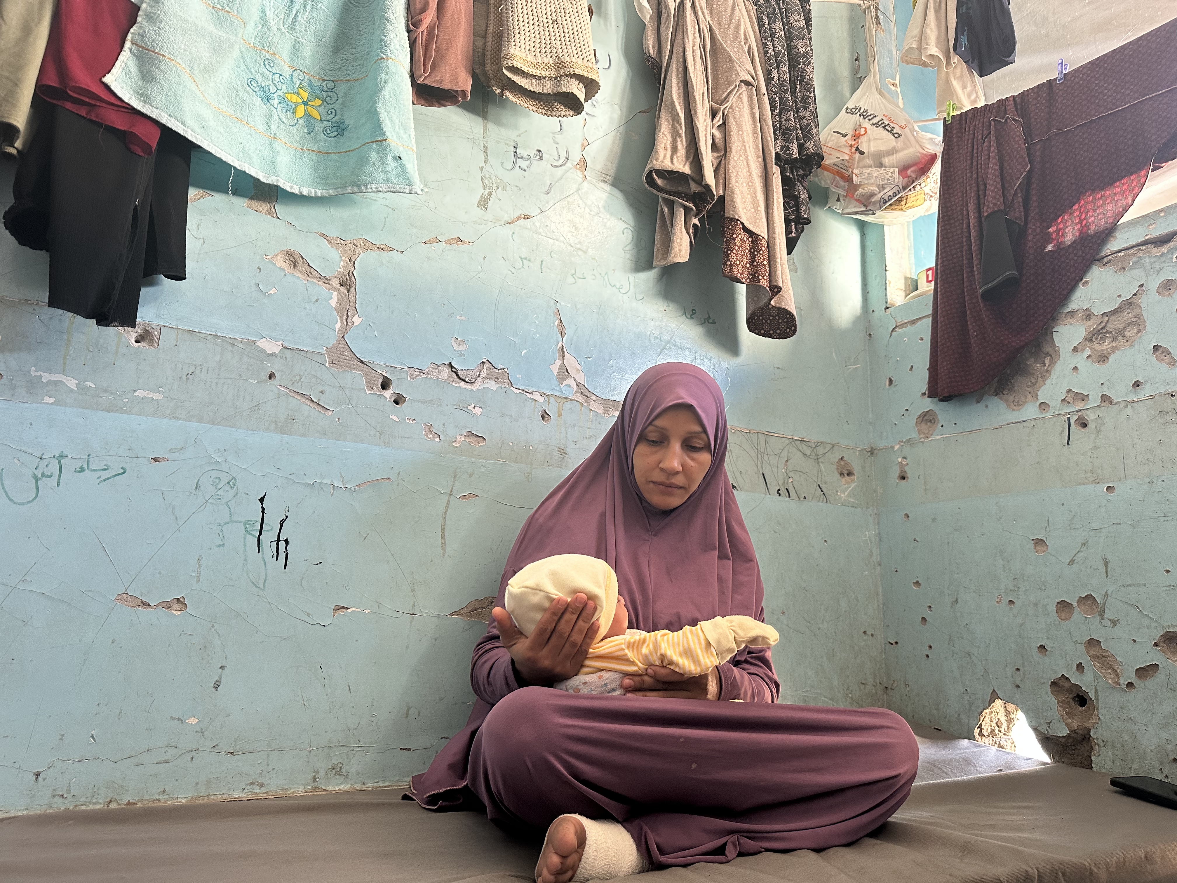 Amal Almasri cradles her newborn daughter, Somod, in a corner of a classroom at a school in western Gaza City where her family is sheltering, on November 5, 2024.